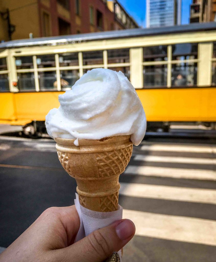 Holding a cone of Lemon Gelato in front of Milan's historic yellow tram, Italy