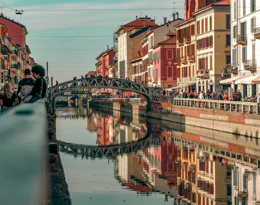 Beautiful terra-cotta colored buildings and bridge over a canal in Navigli district in Milan.