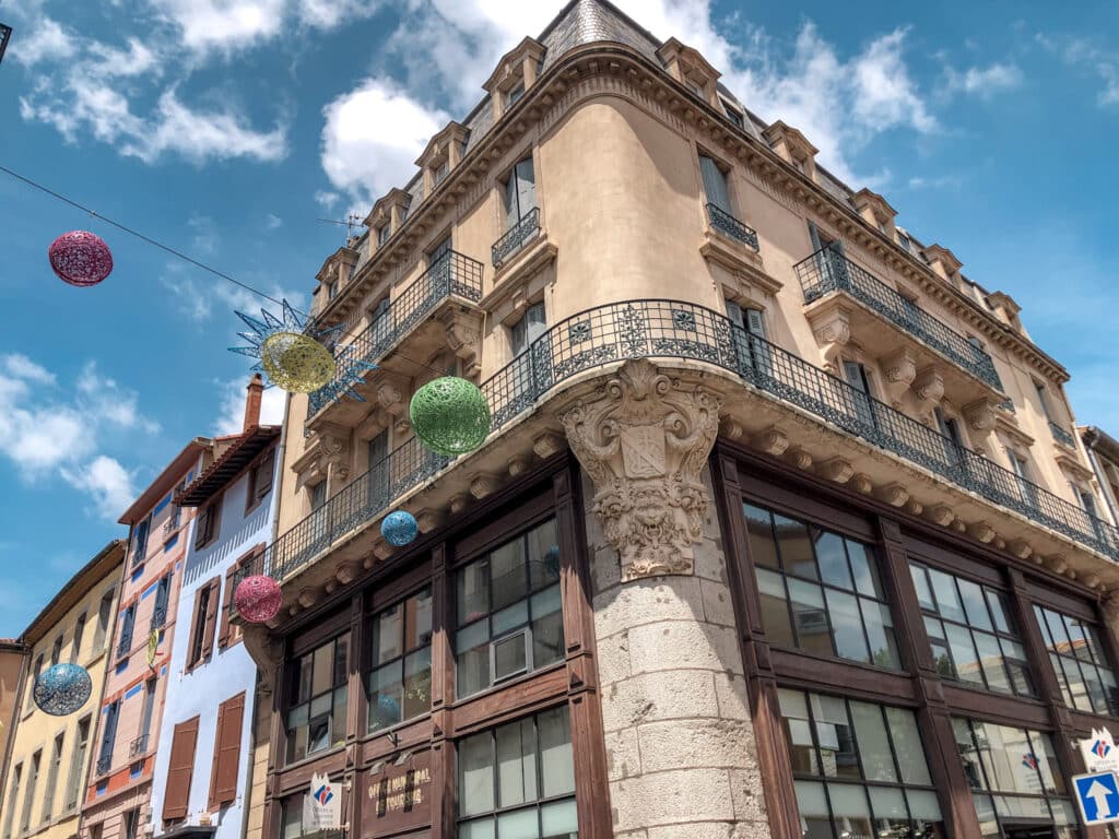A building in Carcassonne France with windows and a balcony against a blue sky