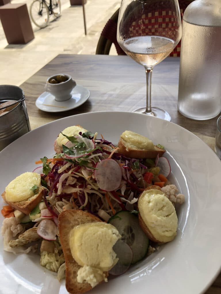 A goat cheese salad and glass of wine in Carcassonne, France