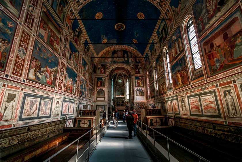 A view of the Scrovigni Chapel interior with frescoes on every wall and ceiling with a distinct blue tying the scene together. 
