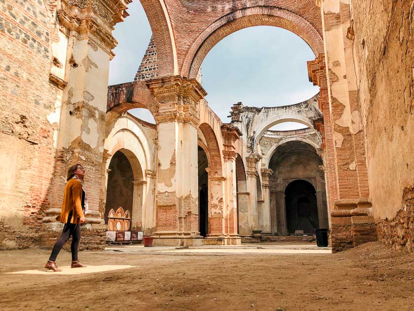 Cate to the left with empty arches of a ruined church from an earthquake above her