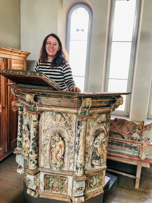 Cate standing in an ornate old pulpit in Sweden